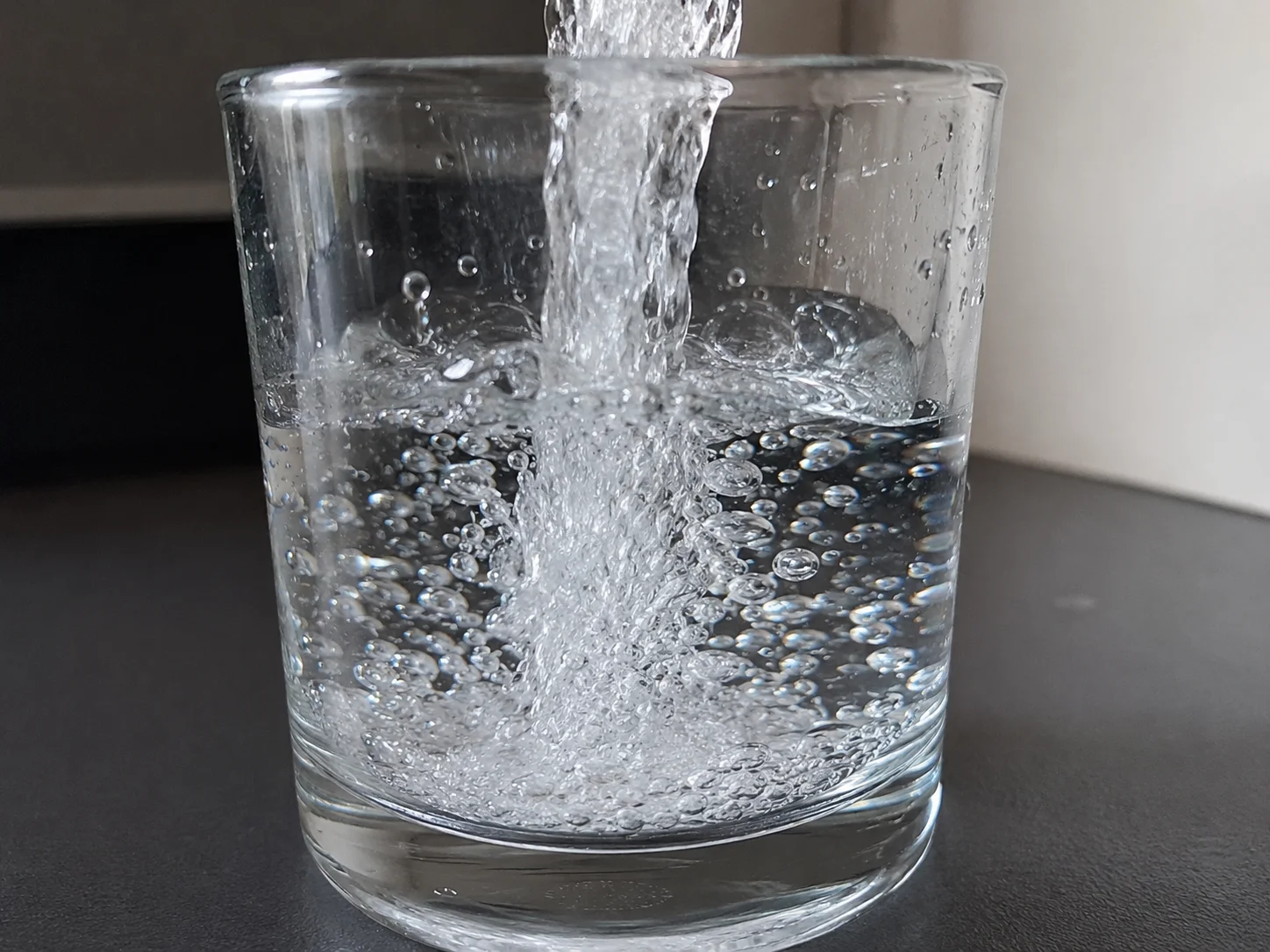 Szklanka krystalicznie czystej wody z odwróconej osmozy chronionej zmiękczaczem.
